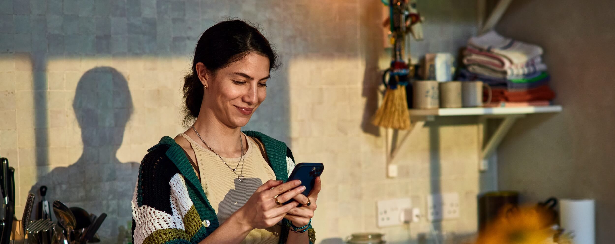 A woman smiles texts on her phone