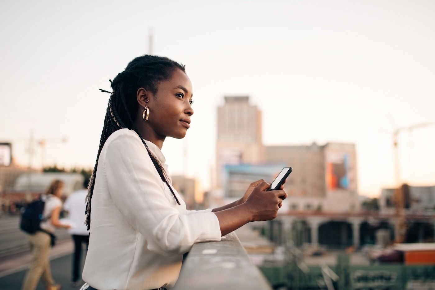 A woman looks out over a vista while getting support on a smartphone